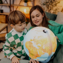Child and woman pointing at a globe